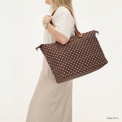 Kvinde med Charm London Buckingham m�rkebrun prikket businessbag over skulderen, der viser taskens st�rrelse og pasform.