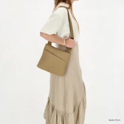 Model med Beagles Calvia skuldertaske i taupe over skulderen