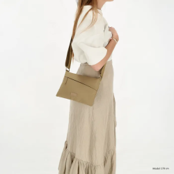 Model med Beagles Calvia skuldertaske i taupe over skulderen