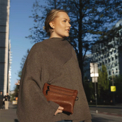 Kvinde med cognacfarvet Duffy crossover taske stylet til hverdagsbrug