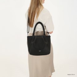 Kvinde med Charm London Lyon sort shopper b�ret over skulderen med den lange rem, som viser taskens pasform og st�rrelse.